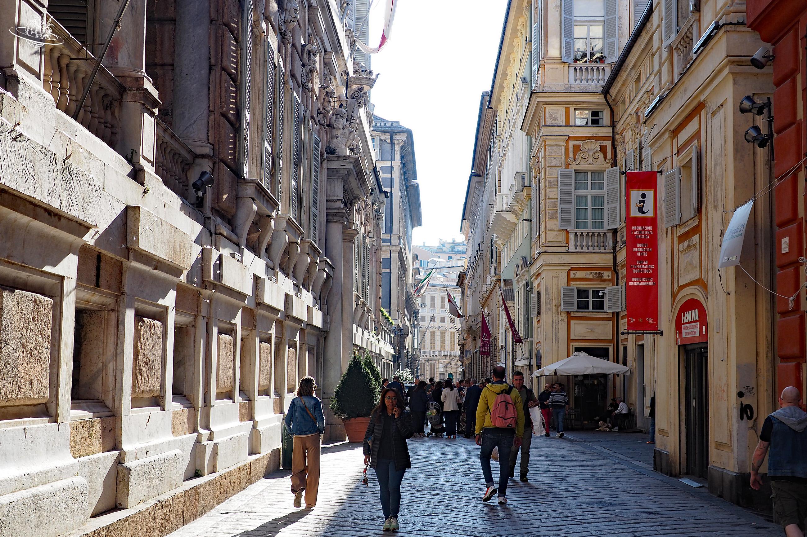 Belebte Gasse mit hohen Häusern