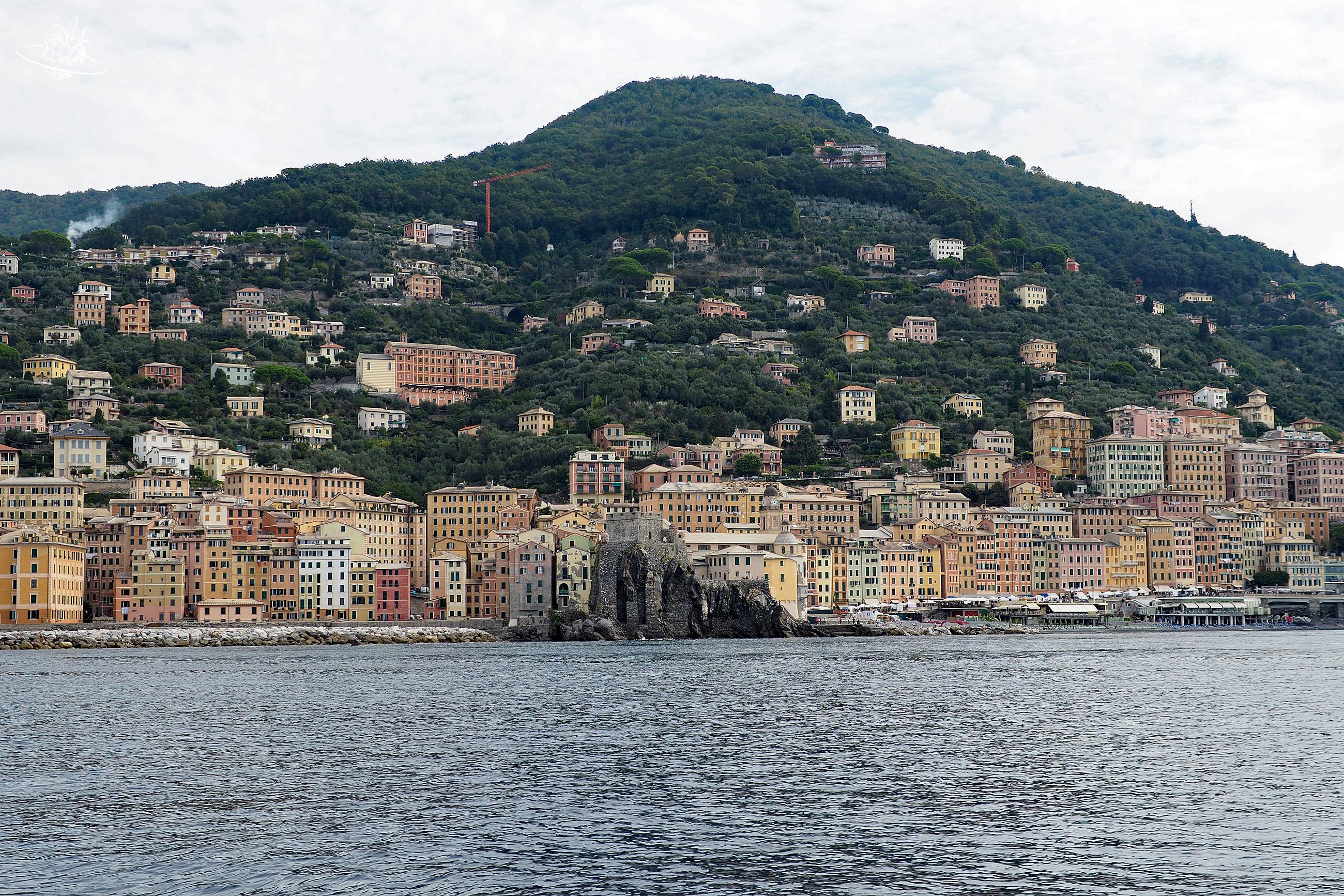 Bebaute Küste mit grünem Berg im Hintergrund