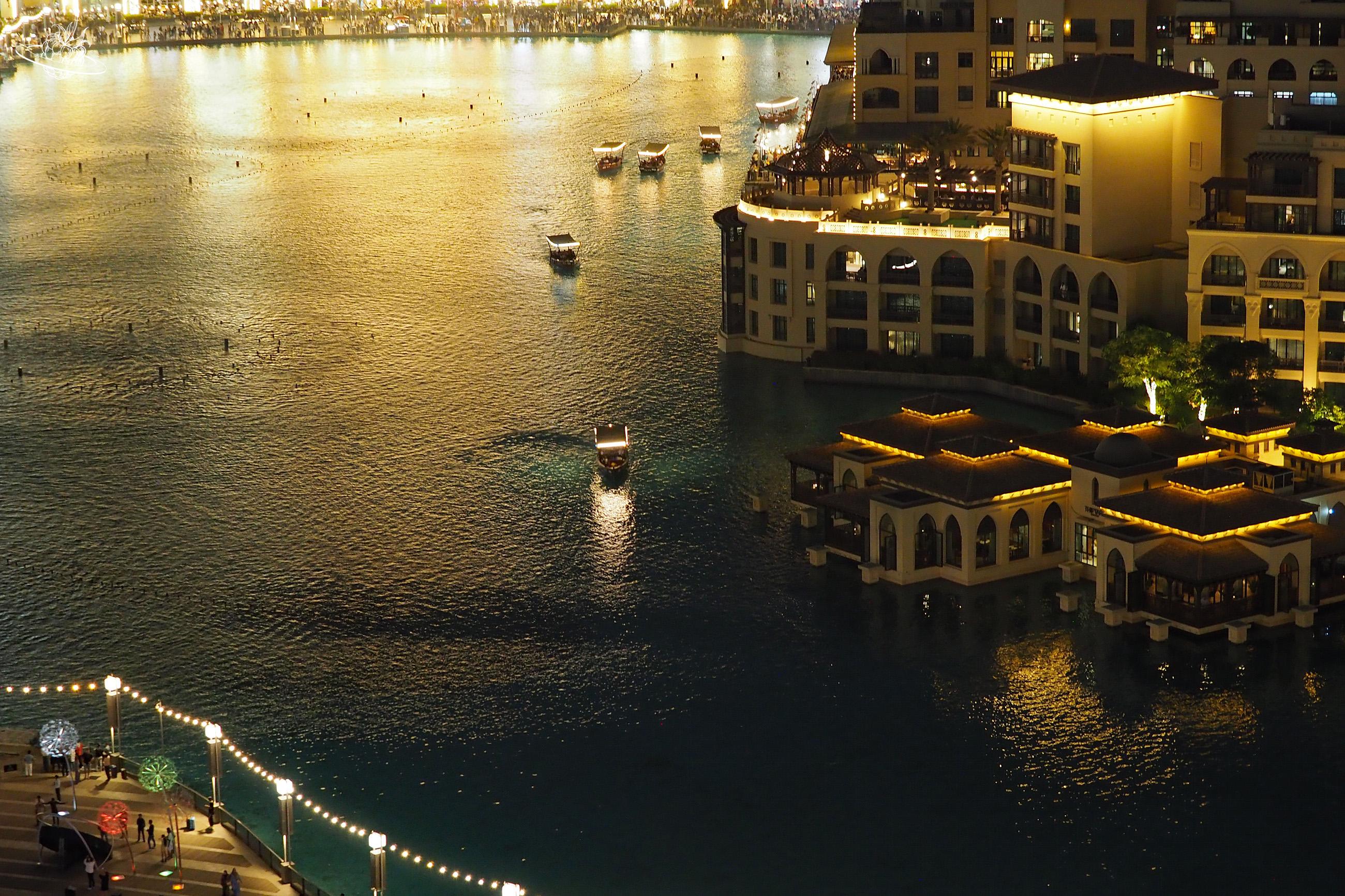 beleuchtete Dubai Mall mit kleinen Booten auf dem Wasser